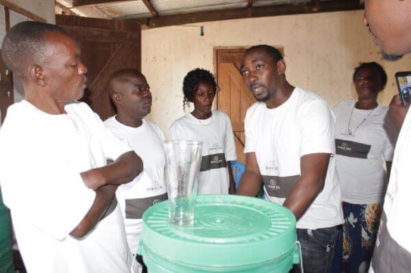 Another photo of SUKHI 222 staff educating the village on how to set up the filter